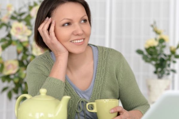woman drinking tea and smiling